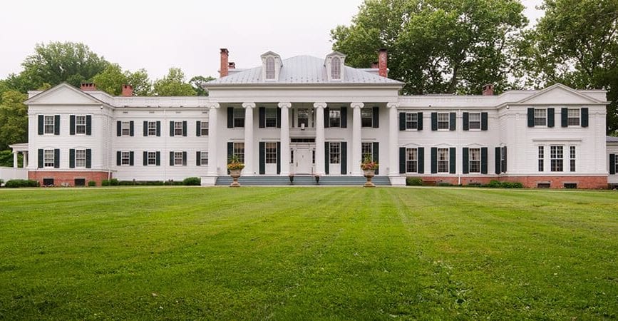 white mansion with large columns and two wings