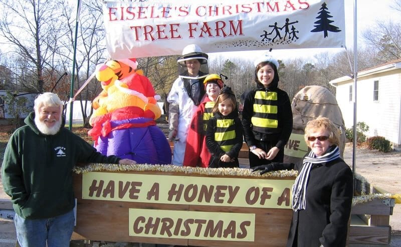 group around sign reading have a honey of a christmas