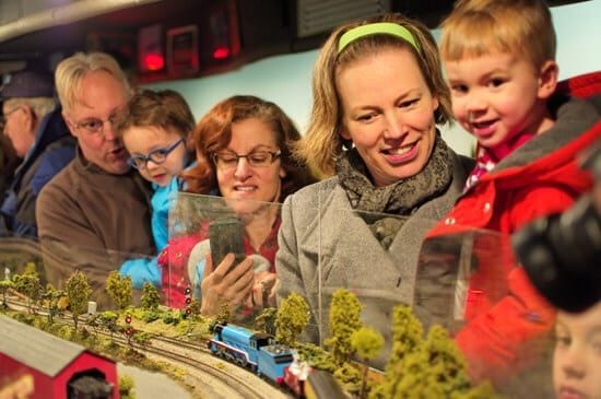 family looking at model railroad