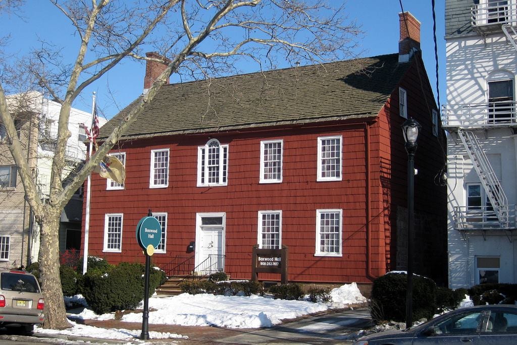 exterior shot of large red flat-front mansion in the snow