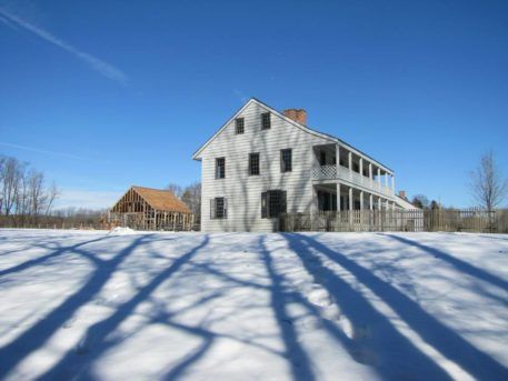 exterior shot of white mansion and picket fence in the snow